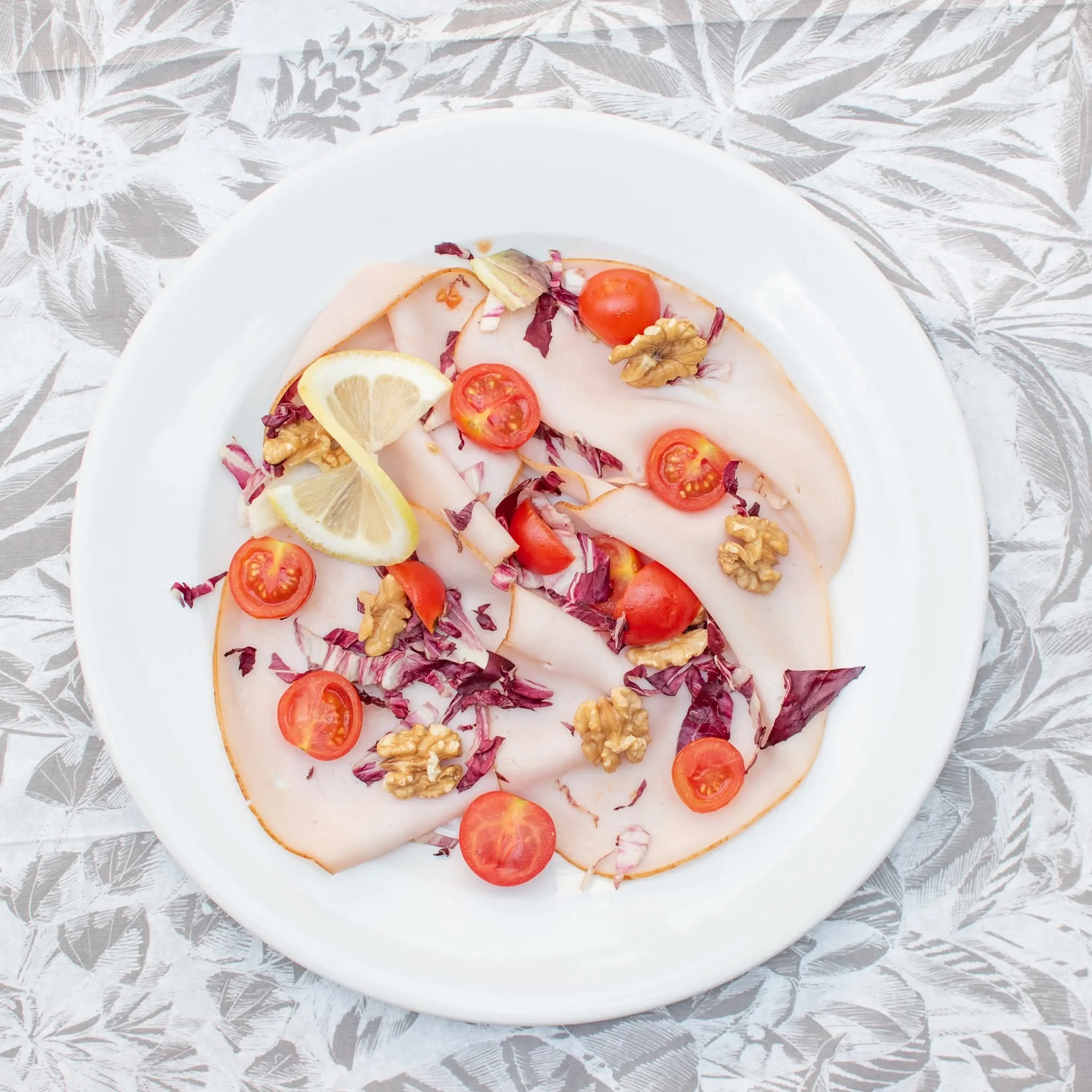 Carpaccio con noci, pomodorini e limone